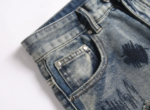 Gros plan de la taille en jean bleu délavé avec rivets et détails brodés