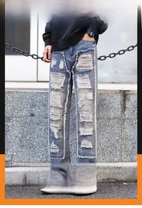 Close-up of light blue washed denim with distressed rectangular patchwork and frayed details