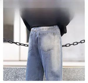 Detail view of men's distressed blue denim jeans showing back pocket and washed texture