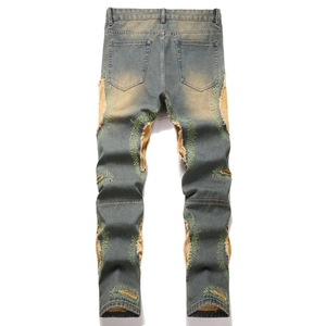 Vintage American style distressed ripped denim jeans with yellow patch and green embroidery