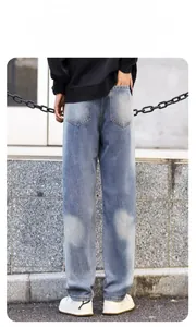 Rear view of distressed blue denim jeans with ripped patches and faded wash finish
