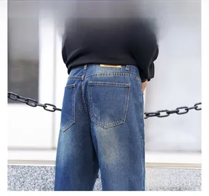 Detail of dark blue washed distressed denim jeans with vintage leather back waist patch