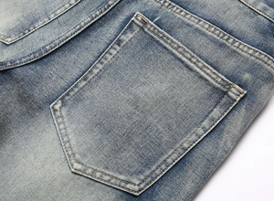 Gros plan sur la poche arrière du jean bleu délavé avec coutures doubles précises