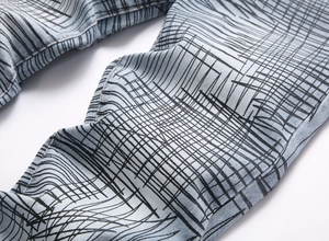 Detail of light blue washed denim with modern black scribble print and twill texture