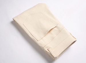Detailed view of rear pocket stitching and cream cotton fabric texture on slim fit trousers