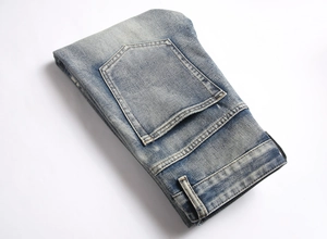 Détail du jean bleu montrant la texture délavée et les coutures de la poche arrière