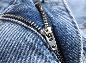 Gros plan d'une fermeture éclair en métal sur un jean bleu pour homme avec tissu en denim