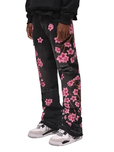 Close-up of pink cherry blossom embroidery and distressed details on black flare jeans