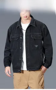 Close-up of heavy denim texture and metal buttons on a black American workwear jacket