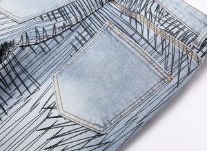 Detailed view of light blue denim back pocket with black graffiti line prints