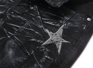 Close-up of black acid-washed denim jeans featuring rhinestone-studded star patchwork