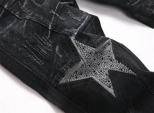 Macro view of distressed black denim with rhinestone-embellished star patch detail