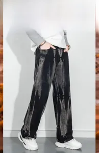 Détail de la texture lourde et du tombé du pantalon en jean noir streetwear large