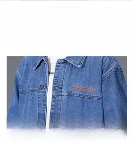 Detail of blue denim jacket showing heavy fabric texture and orange Waveakear embroidery