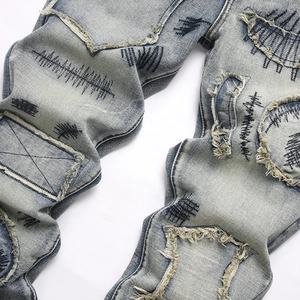 Mens flare jeans with street style embroidery and distressed patchwork detailing