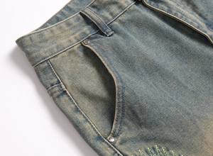 Close-up of vintage washed denim jeans with distressed texture and metal rivet detail