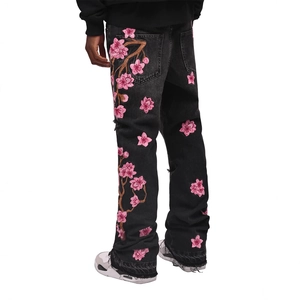 Men's flared denim jeans featuring exquisite pink cherry blossom embroidery and frayed hems