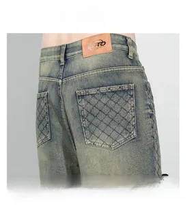 Détail de denim délavé vintage avec broderie matelassée en losange et étiquette en cuir