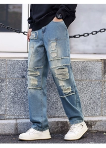 Close-up of distressed denim jeans with vintage ripped details and stylish patches