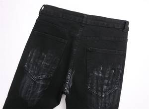 Detailed back view of black stretch flare jeans featuring white sandblasted pockets