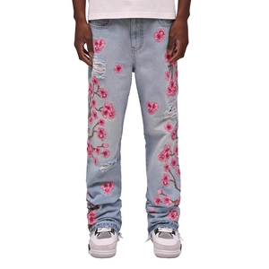 Jean flare homme bleu clair avec broderie fleur de cerisier rose et détails usés