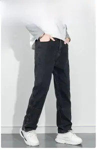 Détail du jean noir pour homme avec coutures aux genoux et fermetures éclair aux chevilles