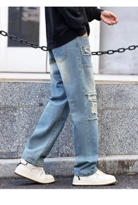 Street style view of light blue distressed jeans with ripped details and straight fit