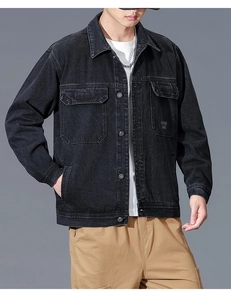 Detailed view of heavy washed black denim fabric with buttoned chest pockets and prints