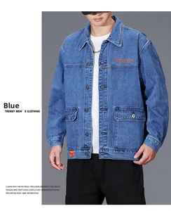 Detail view of denim jacket showing orange letter embroidery and flap pocket on blue fabric