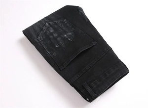 Detailed view of the back pocket and reinforced stitching on black denim jeans