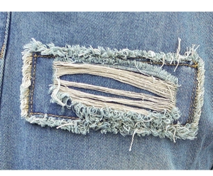 Detailed macro view of distressed denim texture with retro patchwork and frayed edges