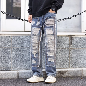 Men's retro wash blue streetwear jeans with heavy distressed patchwork and fringe details