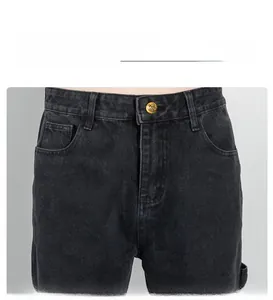 Gros plan détaillé du jean cargo noir avec bouton doré en couronne et texture denim robuste