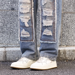 Distressed light blue patch denim jeans for men with ripped holes and streetwear style