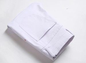 Detailed view of the back pocket stitching and belt loops on white stretch denim trousers
