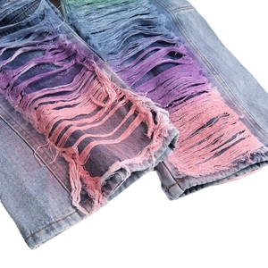 Relaxed light blue jeans with rainbow gradient distressed ripped detailing on legs