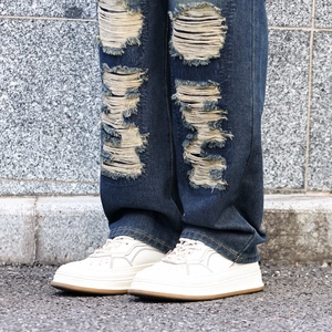 Jean homme bleu coupe droite décontractée avec grandes déchirures et style urbain usé unique