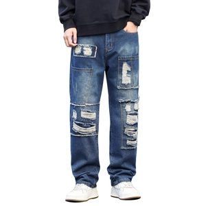 Men's vintage blue distressed jeans with ripped patches and heavy stitching detail