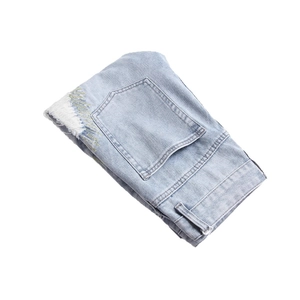 Jean vintage homme bleu clair avec broderies dorées et ourlets effilochés au style urbain