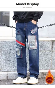 Detail of loose-fit straight jeans with fleece lining, patchwork, and distressed rips