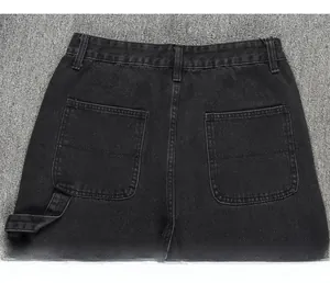 Détail du jean cargo noir délavé montrant les poches arrière et la boucle d'outil