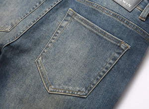 Detail of vintage blue men's stretch jeans showing back pocket and leather waist patch