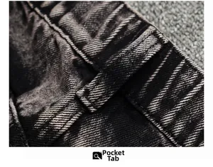 Détail des passants de ceinture renforcés sur un jean gris foncé à effet délavé