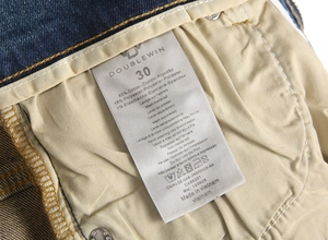 Detailed view of internal wash care label and fabric texture on blue men's jeans