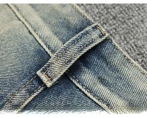 Gros plan d'un jean vintage avec coutures jaunes et texture denim délavée vieillie