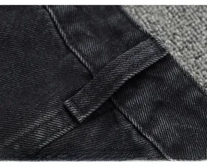 Détail macro des passants de ceinture et des coutures sur un jean cargo noir