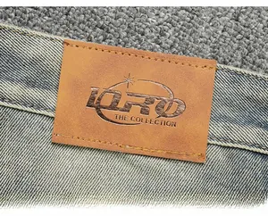 Gros plan détaillé d'un jean bleu délavé rétro avec étiquette de taille en cuir brun