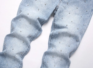 Close-up of light blue flare jeans with decorative rhinestones and glitter coating