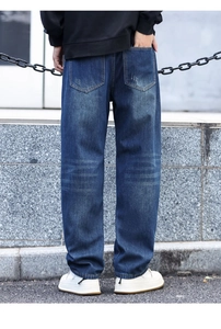 Detail of loose-fit distressed jeans with whiskers wash and patch design for men