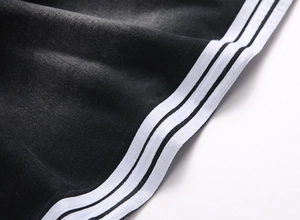 Gros plan du denim noir délavé avec trois bandes blanches latérales parallèles